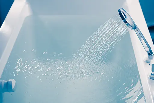 Shower filling a bathtub with water stream